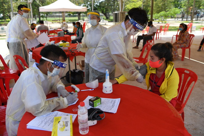 Nhân viên y tế xét nghiệm COVID-19 cho dân tại Phnom Penh, Campuchia. (Ảnh: AFP/TTXVN) Campuchia hỗ trợ các địa phương có nhiều lao động về nước cách ly ảnh 1