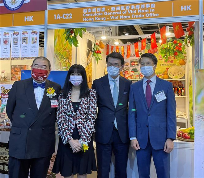 Cục trưởng Phát triển Thương mại và kinh tế Hong Kong Khâu Đằng Hoa cùng đại diện HKTDC và Tổng Lãnh sự Việt Nam tại Hong Kong Phạm Bình Đàm tại gian hàng trưng bày của Việt Nam. (Ảnh: TTXVN) Việt Nam tham dự Hội chợ Thực phẩm Hong Kong năm 2021 ảnh 2