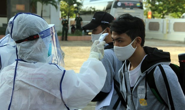 Đo thân nhiệt cho người cách ly. (Nguồn: TTXVN) Việt Nam ghi nhận thêm 1 ca mắc COVID-19 mới từ Đức nhập cảnh ảnh 1