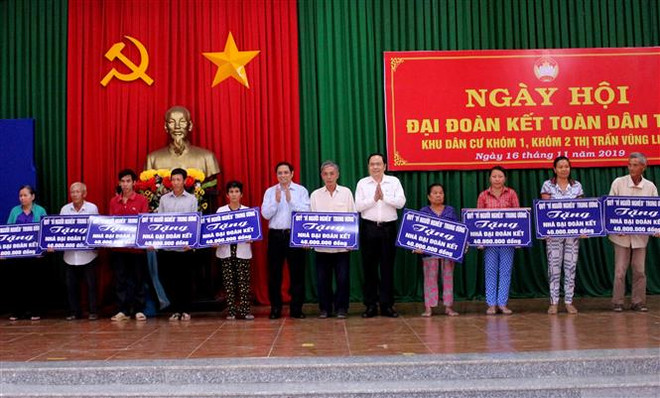 Trưởng ban Tổ chức Trung ương Phạm Minh Chính và Chủ tịch Ủy ban Trung ương Mặt trận Tổ quốc Việt Nam Trần Thanh Mẫn trao bảng tượng trưng nhà Đại đoàn kết cho hộ nghèo huyện Vũng Liêm, tỉnh Vĩnh Long. (Ảnh: Lê Thúy Hằng/TTXVN) Trưởng Ban Tổ chức Trung ương dự Ngày hội Đại đoàn kết tại Vĩnh Long ảnh 2