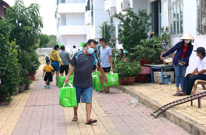 Chuyển nhu yếu phẩm đến cho người dân đang cách ly tại khu C, chung cư Văn Thánh, phường Phú Tài, thành phố Phan Thiết. (Ảnh: Nguyễn Thanh/TTXVN) Bình Thuận: Thêm một huyện giãn cách xã hội để phòng, chống dịch ảnh 1