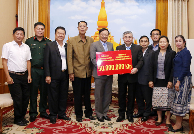 Đại sứ Nguyễn Bá Hùng trao cho Thứ trưởng Bộ Lao động và Phúc lợi xã hội Lào Padeumphone Xonthavy số tiền 50 triệu kip để giúp người dân Lào bị ảnh hưởng bởi lũ lụt nhanh chóng khắc phục và ổn định cuộc sống. (Ảnh: Phạm Kiên/Vietnam+) Người Việt tại Lào hỗ trợ người dân vùng lũ lụt ở Savannakhet ảnh 1