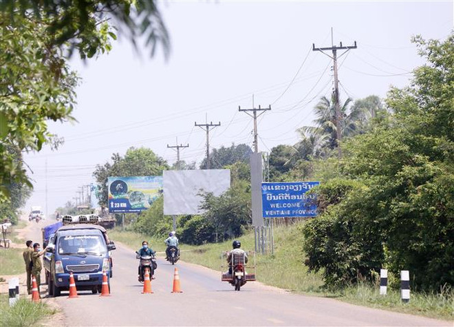 Công an lập chốt tại các xã, phường tiếp giáp của thủ đô Vientiane với các tỉnh lân cận. (Ảnh: Phạm Kiên/TTXVN) Lào lần thứ 10 gia hạn phong tỏa, đẩy mạnh tiêm chủng vaccine COVID-19 ảnh 1