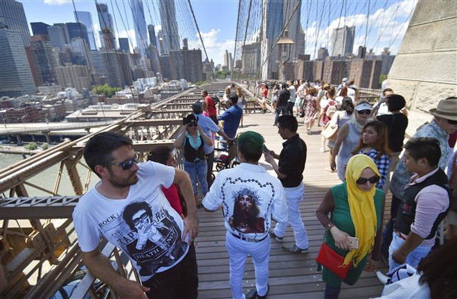 Khách du lịch trên cầu Brooklyn, New York, Mỹ. (Ảnh: AFP/TTXVN) Fed: Dịch COVID-19 có thể tác động bất lợi đến kinh tế Mỹ ảnh 1