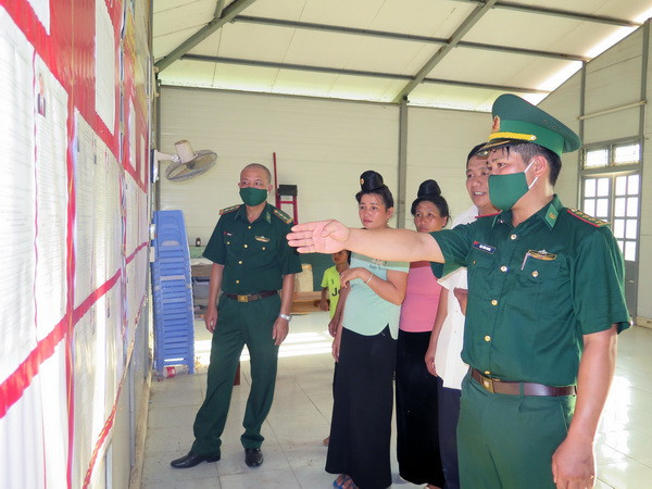 Cán bộ Đồn biên phòng cửa khẩu Chiềng Khương thuộc Bộ Chỉ huy Bộ đội Biên phòng tỉnh Sơn La, hướng dẫn người dân tìm hiểu về danh sách đại biểu Quốc hội và HĐND các cấp. (Ảnh: Hữu Quyết/TTXVN) Bộ đội Biên phòng Sơn La đẩy mạnh tuyên truyền bầu cử ở vùng biên ảnh 1