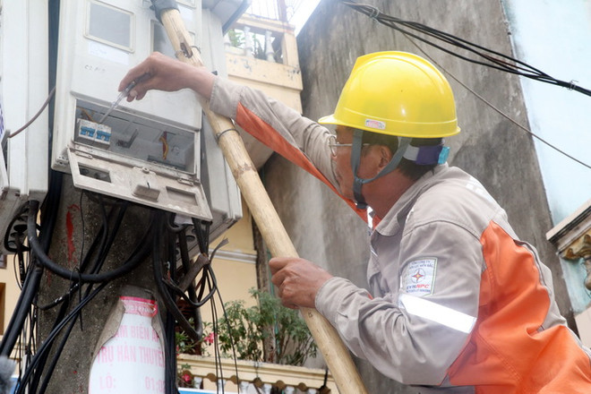 Công nhân Điện lực kiểm tra đồng hồ đo điện của các hộ dân. (Ảnh: Văn Đạt/TTXVN) Kon Tum: Xuất hiện tình trạng giả danh nhân viên điện lực đòi nợ tiền ảnh 1