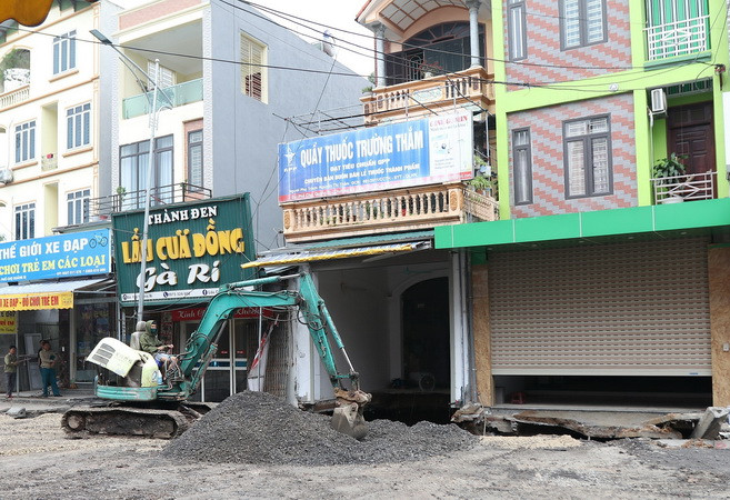 Lực lượng chức năng đang thực hiện việc san lấp "hố tử thần" rộng khoảng 100m2 xuất hiện nhiều ngày nay ở xã Quảng Bị, huyện Chương Mỹ, Hà Nội. (Ảnh: Lê Phú/TTXVN) Cơ bản hoàn thành khắc phục sự cố sụt lún đất ở huyện Chương Mỹ ảnh 1