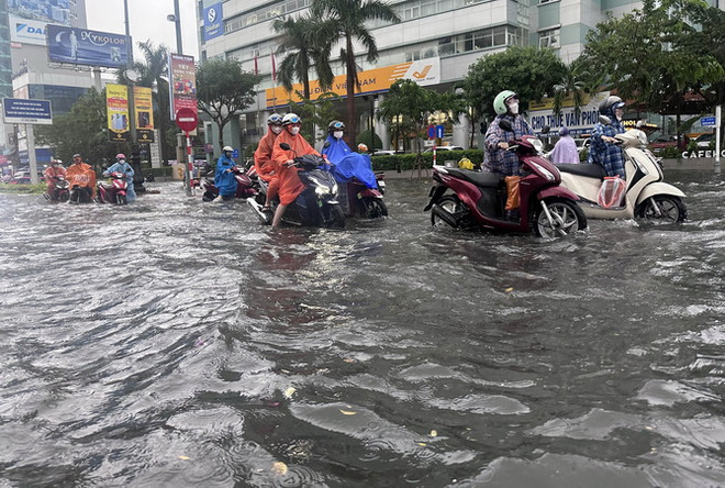 Đường Nguyễn Văn Linh ngập sâu trong nước, người dân phải dắt bộ phương tiện. (Ảnh: Trần Lê Lâm/TTXVN) Thừa Thiên-Huế, Quảng Nam, Đà Nẵng ứng phó với áp thấp nhiệt đới ảnh 2