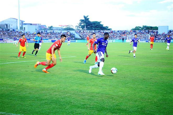 Romario (Hà Nội FC) đi bóng trước sự đeo bám của các cầu thủ Hồng Lĩnh Hà Tĩnh. (Ảnh: Phan Quân/TTXVN) Hà Tĩnh chia điểm với Hà Nội sau sự cố khán giả tràn xuống sân ảnh 1