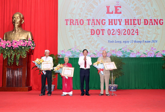 Bí thư Tỉnh ủy Vĩnh Long Bùi Văn Nghiêm trao Huy hiệu 70 năm và 65 năm tuổi Đảng cho các đảng viên. (Ảnh: Phạm Minh Tuấn/TTXVN) ttxvn_1308_huy hieu dang (2).jpg