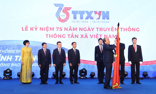 Thủ tướng Nguyễn Xuân Phúc gắn Huân chương Lao động hạng Nhất lên lá cờ truyền thống của Thông tấn xã Việt Nam. (Ảnh: Thống Nhất/TTXVN) Thủ tướng: TTXVN cần giữ vững vị thế trung tâm thông tin tin cậy ảnh 3