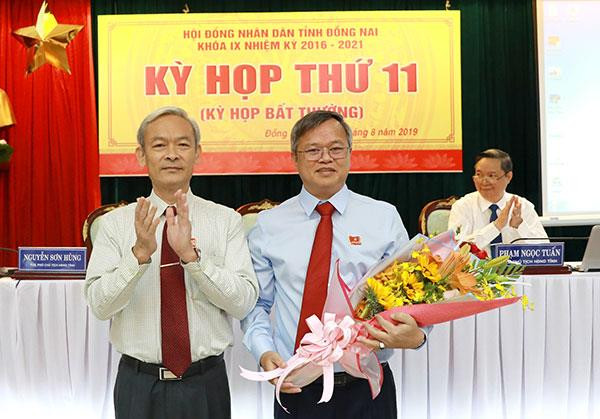 Bí thư Tỉnh ủy, Chủ tịch Hội đồng Nhân dân tỉnh Nguyễn Phú Cường (trái) tặng hoa chúc mừng ông Cao Tiến Dũng. (Nguồn: baodongnai.com.vn) Ông Cao Tiến Dũng được bầu làm Chủ tịch Ủy ban Nhân dân tỉnh Đồng Nai ảnh 1