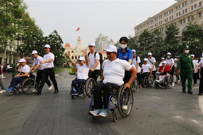 Đông đảo vận động viên khuyết tật 19 tỉnh thành phố trong cả nước tham gia đi bộ đồng hành tại chương trình chào mừng ngày người khuyết tật Việt Nam (18/4). (Ảnh: Thanh Vũ/TTXVN) Phát huy sự nỗ lực của người khuyết tật tham gia hoạt động xã hội ảnh 2
