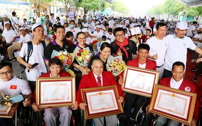 Các huấn luyện viên, vận động viên nhận Bằng khen của Thủ tướng Chính phủ tại chương trình. (Ảnh: Thanh Vũ/TTXVN) Phát huy sự nỗ lực của người khuyết tật tham gia hoạt động xã hội ảnh 4