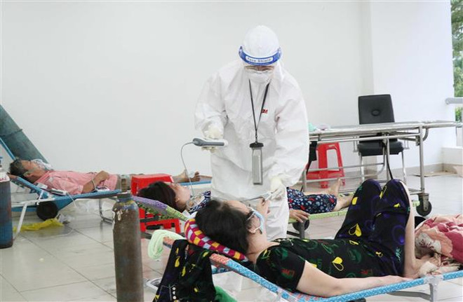 Các bác sỹ thăm khám bệnh nhân nhiễm COVID-19 không triệu chứng có bệnh nền. (Ảnh: Xuân Khu/TTXVN) Khẩn trương thực hiện các biện pháp phòng, chống COVID-19 tại TP.HCM ảnh 1