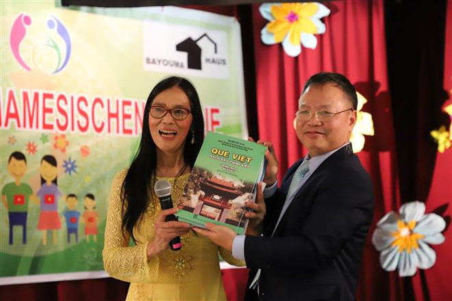 Ông Phan Quang Văn - Bí thư thứ nhất, phụ trách bộ phận giáo dục của Đại sứ quán Việt Nam tại CHLB Đức, tặng sách giáo khoa dạy tiếng Việt cho Trường tiếng Việt AWO. (Ảnh: Phương Hoa/TTXVN) ttxvn_2011_AWO (3).jpg