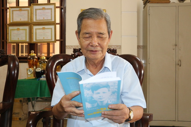 Ông Phạm Thanh Phong xem lại cuốn hồi ký khi vào Chiến khu Cách mạng. (Ảnh: Thanh Bình/TTXVN) Người làm báo cần phải nâng cao và trau dồi đạo đức hơn nữa ảnh 1