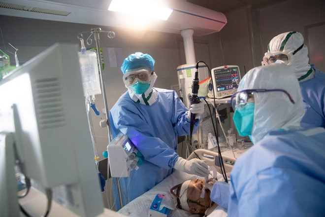 Nhân viên y tế điều trị cho bệnh nhân COVID-19 tại bệnh viện. (Ảnh: AFP/TTXVN) Thượng Hải đạt mục tiêu cắt đứt lây nhiễm COVID-19 trong cộng đồng ảnh 1