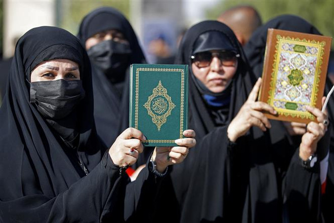 Người Hồi giáo Iraq tuần hành phản đối việc đốt kinh Koran bên ngoài Đại sứ quán Thụy Điển ở thủ đô Baghdad. (Ảnh: AFP/TTXVN) Đại sứ quán Thụy Điển ở thủ đô Baghdad của Iraq bị phóng hỏa ảnh 1