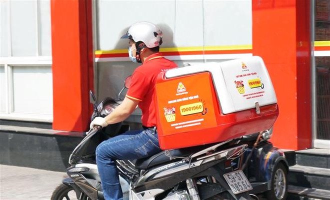 Doanh nghiệp đảm bảo phương tiện vận chuyển hàng hóa an toàn đến tay người tiêu dùng. (Ảnh: TTXVN phát) Ngành bán lẻ chuyển hướng theo xu thế hiện đại để đối phó với dịch ảnh 1