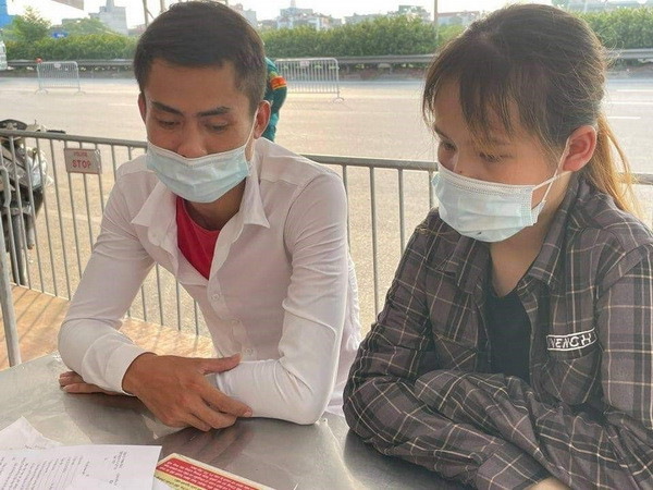 Đôi nam nữ đưa ra 2 giấy đi đường ký khống để "thông" chốt. (Ảnh: TTXVN phát) Phát hiện 2 đối tượng dùng Giấy đi đường ký khống để "thông" chốt ảnh 1