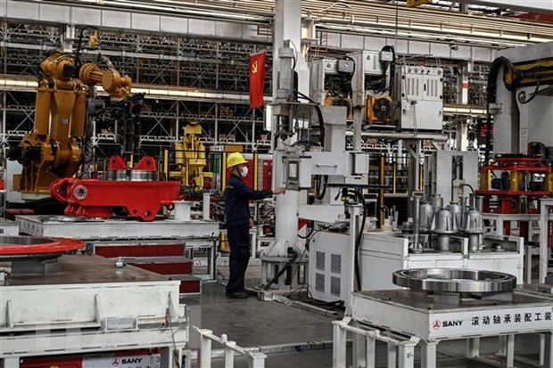 Công nhân làm việc tại một máy lắp ráp ở Bắc Kinh, Trung Quốc. (Ảnh: AFP/TTXVN) Kinh tế Trung Quốc phục hồi nhanh hơn nhưng vẫn tiềm ẩn nhiều rủi ro ảnh 1