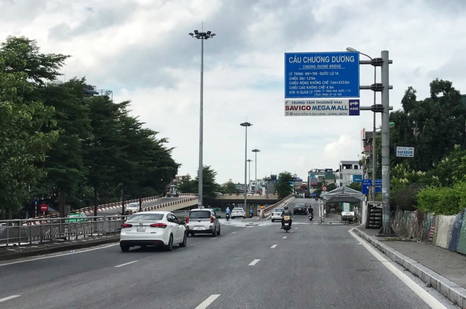 Người di chuyển qua chốt phía chân cầu Chương Dương không phải dừng để kiểm soát giấy tờ. (Ảnh: Minh Quyết/TTXVN) Công an thành phố Hà Nội tiếp tục duy trì 55 chốt kiểm soát dịch ảnh 1