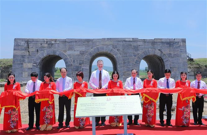 Đại sứ Hoa Kỳ tại Việt Nam Daniel Kritenbrink và Phó Chủ tịch UBND tỉnh Thanh Hóa Nguyễn Đức Quyền thực hiện nghi lễ cắt băng khánh thành Dự án tu sửa mái vòm và bảo tồn cổng thành phía Nam Thành nhà Hồ. (Ảnh: TTXVN phát) Khánh thành dự án tu sửa mái vòm và bảo tồn cổng phía Nam Thành nhà Hồ ảnh 1