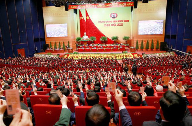 Các đại biểu biểu quyết, thông qua Nghị quyết Đại hội XIII Đảng Cộng sản Việt Nam. (Ảnh: TTXVN) Chuyên gia quốc tế nêu cao vai trò Đảng Cộng sản Việt Nam ảnh 1