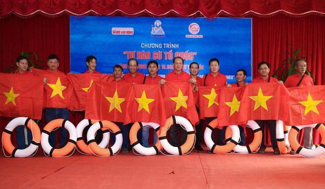 Báo Người Lao Động tặng cờ Tổ quốc cho ngư dân Ninh Thuận. (Ảnh: Công Thử/TTXVN) Trao tặng 10 ngàn lá cờ Tổ quốc cho ngư dân Ninh Thuận ảnh 1