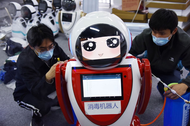 Các kỹ thuật viên kiểm tra robot khử trùng thế hệ đầu tiên tại công ty công nghệ Thanh Đảo, tỉnh Sơn Đông, Trung Quốc ngày 11/2 vừa qua. (Ảnh: THX/TTXVN) Trung Quốc tăng cường ứng dụng công nghệ thông tin trong dịch COVID-19 ảnh 1
