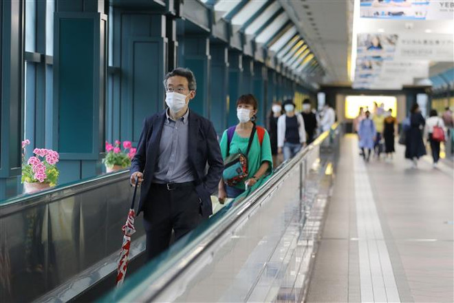 Người dân đeo khẩu trang phòng lây nhiễm COVID-19 tại Tokyo, Nhật Bản. (Ảnh: THX/TTXVN) Hàn Quốc ghi nhận 49 ca mới, Nhật bỏ tất cả hạn chế đi lại trong nước ảnh 2