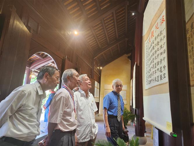 Nhiều nhà nghiên cứu văn hóa Huế quan tâm, thưởng ngoạn các bức thư pháp tái hiện "Thần kinh nhị thập cảnh" của vua Thiệu Trị. (Ảnh: Mai Trang/TTXVN) Triển lãm thơ vua Thiệu Trị qua thư pháp Truyền thừa của Đài Loan ảnh 2
