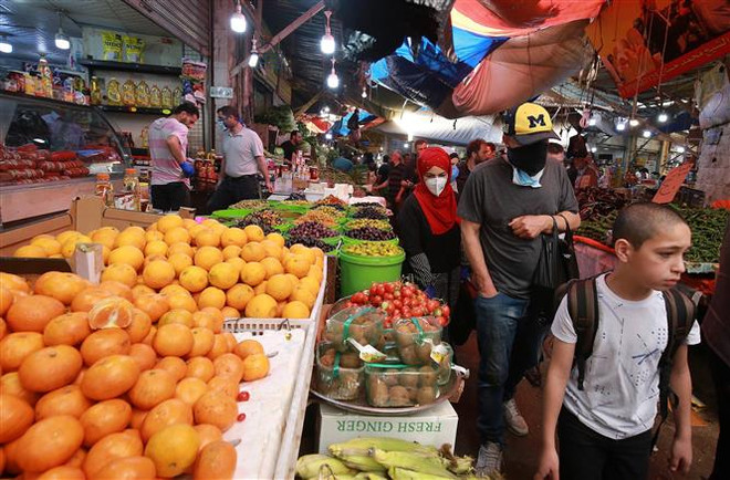 Người dân mua sắm tại một khu chợ ở Amman, Jordan. (Ảnh: AFP/TTXVN) 15.700 ca tử vong, hệ thống y tế Iran quá tải do COVID-19 ảnh 2
