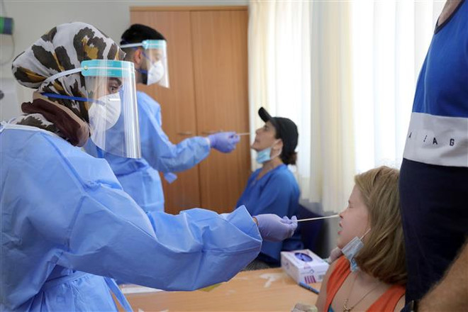 Nhân viên y tế lấy mẫu xét nghiệm COVID-19 tại Or Yehuda, Israel. (Ảnh: AFP/TTXVN) 15.700 ca tử vong, hệ thống y tế Iran quá tải do COVID-19 ảnh 3