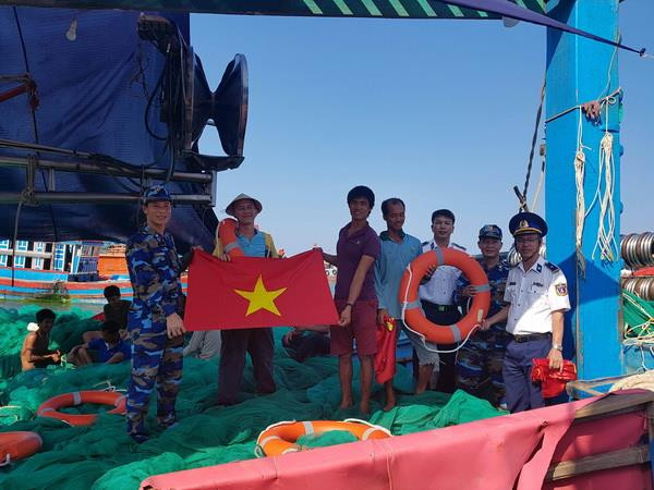 Tặng cờ Tổ quốc cho ngư dân. (Ảnh: Trần Tĩnh/TTXVN) Tặng cờ Tổ quốc - tiếp sức ngư dân vươn khơi, bám biển ảnh 1