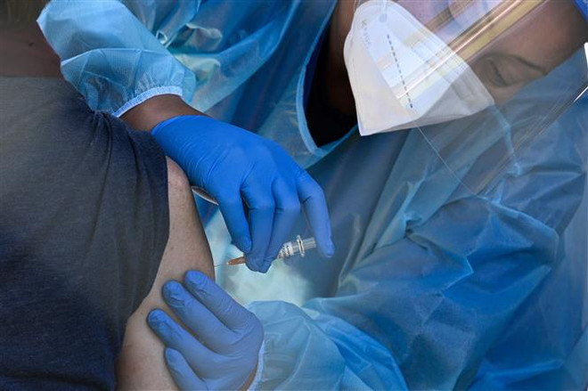 Nhân viên y tế tiêm vaccine cho người dân tại San Fernando, California, Mỹ. (Ảnh: AFP/TTXVN) Mỹ tiêm mũi 2 vaccine COVID-19 thể lưỡng trị cho người cao tuổi ảnh 1