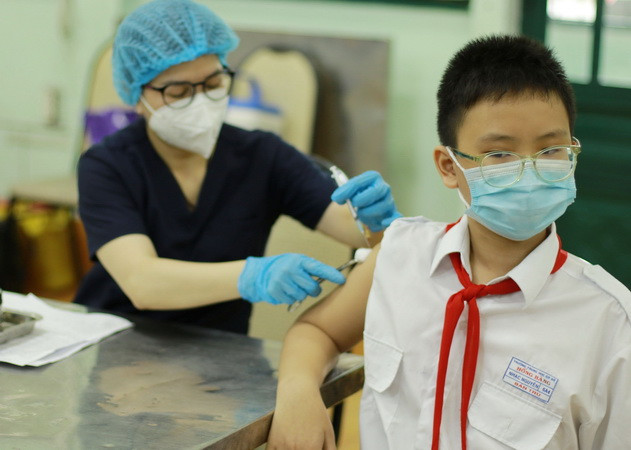 Nhân viên y tế tiêm vaccine phòng COVID-19 cho học sinh trường Trung học cơ sở Hồng Bàng, quận 5. (Ảnh: Thu Hương/TTXVN) TP.HCM: Chưa ghi nhận trẻ từ 5 đến dưới 12 tuổi có phản ứng sau tiêm ảnh 1