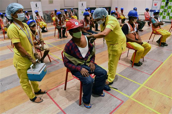Tiêm chủng vaccine ngừa COVID-19 cho công nhân xây dựng ở Mumbai, Ấn Độ. (Ảnh: AFP/TTXVN) Ấn Độ lập kỷ lục về số liều vaccine COVID-19 tiêm trong một ngày ảnh 1