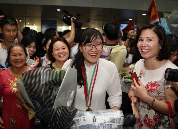 Em Nguyễn Phương Thảo, Trường THPT chuyên Khoa học Tự nhiên, Đại học Quốc gia Hà Nội, trong sự chào đón của người thân và bè bạn. (Ảnh: Thanh Tùng/TTXVN) Gặp gỡ nữ sinh Việt có điểm thi cao nhất Olympic Sinh học quốc tế 2018 ảnh 1