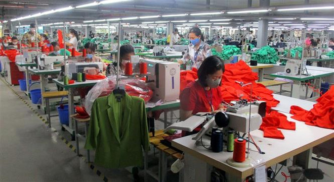 Công nhân Nhà máy may xuất khẩu Sơn Hà (thị xã Bỉm Sơn) bị giảm thu nhập do công ty thiếu đơn hàng. (Ảnh: Nguyễn Nam/TTXVN) Ổn định thị trường lao động cuối năm: Để người lao động vui đón Tết ảnh 1
