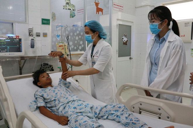 Các bác sỹ Bệnh viện Nhi đồng Đồng Nai đang kiểm tra vận động tay chân cho bệnh nhi sau khi hồi phục. (Ảnh: Lê Xuân/TTXVN) ttxvn_2708_set danh (1).jpg