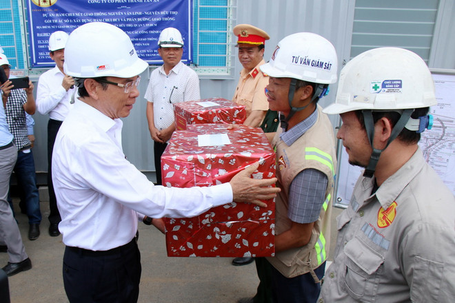 Bí thư Thành ủy Thành phố Hồ Chí Minh Nguyễn Văn Nên tặng quà các đơn vị thi công và lực lượng điều tiết giao thông qua khu vực nút giao Nguyễn Văn Linh-Nguyễn Hữu Thọ. (Ảnh: Tiến Lực/TTXVN) ttxvn_ong Nen2.jpg
