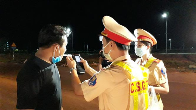 Lực lượng Cảnh sát giao thông kiểm tra đo nồng độ cồn của người tham gia giao thông. (Ảnh: Chanh Đa/TTXVN) Tuần cao điểm, hơn 5.000 tài xế bị phạt vì có cồn trong hơi thở ảnh 1