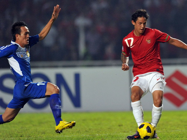 Tiền đạo Irfan Bachdim (phải), đội Indonesia trong pha tranh bóng với cầu thủ Kovanh Namthavixay, đội Lào. (Ảnh: AFP/TTXVN) AFF Suzuki Cup 2016: Tuyển Indonesia liên tiếp nhận hung tin ảnh 1