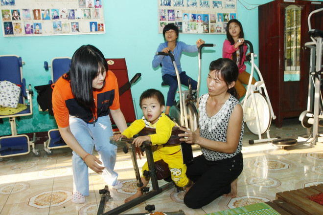 Các tình nguyện viên người Hàn Quốc phục hồi chức năng cho trẻ em khuyết tật. (Ảnh: Hồ Cầu/TTXVN) Trên 1,5 tỷ đồng phục hồi chức năng cho trẻ khuyết tật ở Bình Định ảnh 1