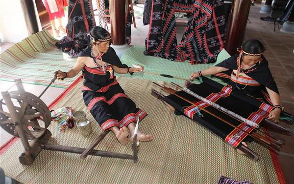 Trình diễn quay sợi, dệt thổ cẩm của dân tộc Giẻ Triêng tỉnh Kon Tum. (Ảnh: Hồ Cầu/TTXVN) Tôn vinh bản sắc văn hóa các dân tộc vùng biên giới Việt-Lào ảnh 3