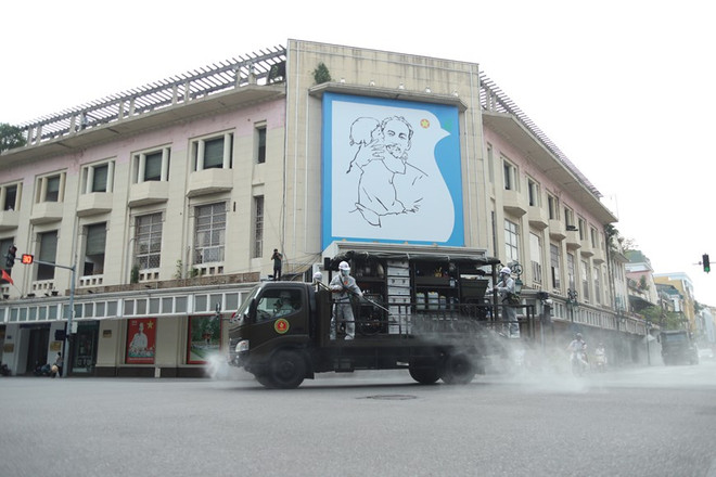 Lực lượng chức năng phun khử khuẩn khu vực quận Hoàn Kiếm. (Ảnh: Hoàng Đạt/Vietnam+) Hà Nội tiến hành phun khử khuẩn diện rộng để phòng dịch COVID-19 ảnh 1