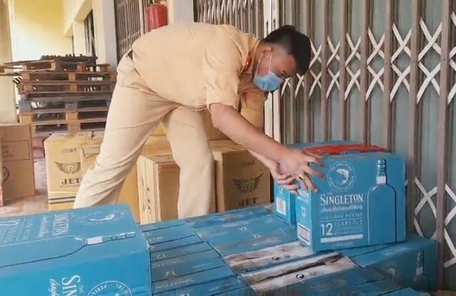 Lực lượng chức năng kiểm đếm số hàng lậu bị bắt giữ. (Ảnh: TTXVN phát) Quảng Trị: Thu giữ xe ôtô vận chuyển một lượng lớn hàng lậu ảnh 1