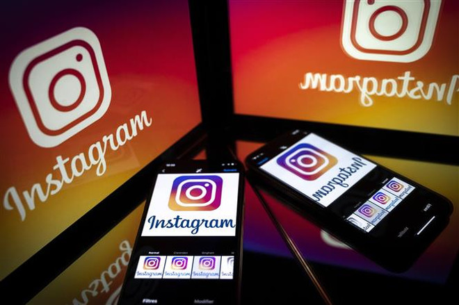 Biểu tượng của Instagram trên màn hình máy tính bảng và điện thoại. (Ảnh: AFP/TTXVN) Facebook gỡ bỏ hàng trăm tài khoản Instagram bị đánh cắp thông tin ảnh 1
